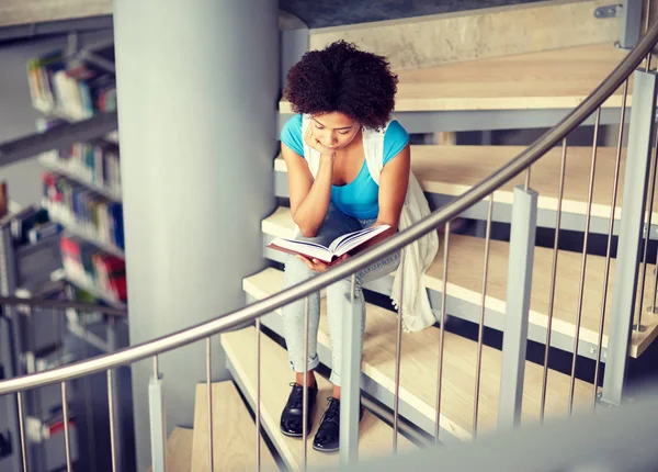 Afrikanska student tjej läsa bok på biblioteket — Stockfoto
