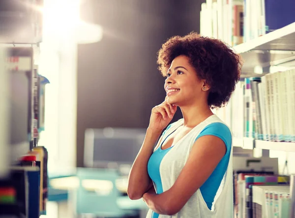 Africano studente ragazza in cerca di libro a biblioteca — Foto Stock