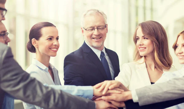 Gente de negocios poniendo manos en la parte superior en la oficina — Foto de Stock