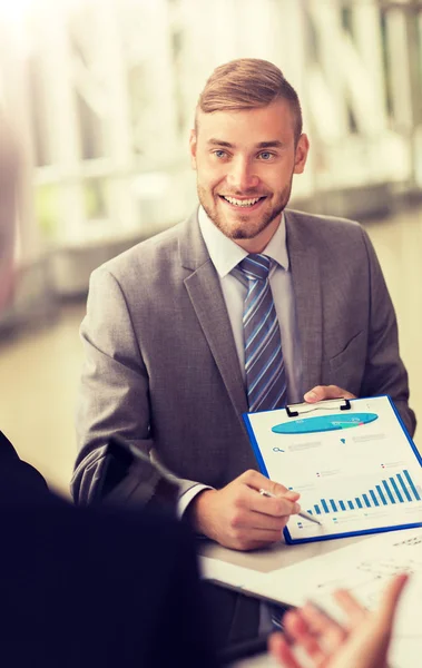 Smiling businessman with graph at business meeting — Stock Photo, Image