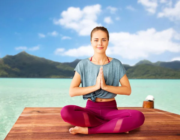 Mujer haciendo yoga y meditando en pose de loto — Foto de Stock