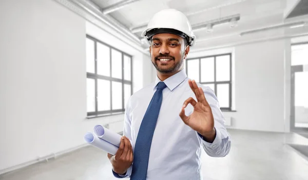 Arquitecto en casco con planos que muestran ok — Foto de Stock