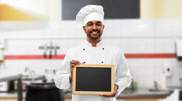 Indischer Koch mit Tafel in der Restaurantküche — Stockfoto