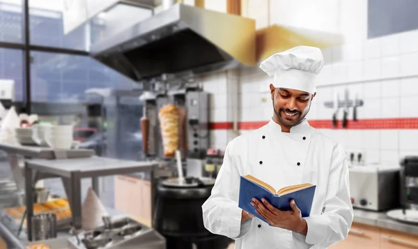 Szczęśliwy Indyjski szef kuchni czytanie Cookbook w Kebab Shop — Zdjęcie stockowe