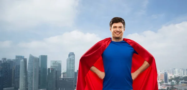 Человек в красном плаще супергероя над Сингапором — стоковое фото