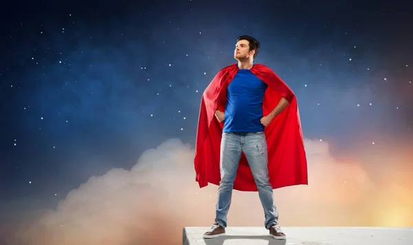 Man in red superhero cape over night sky — Stock Photo, Image