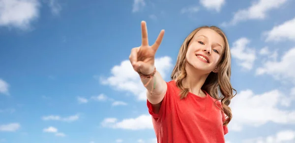 Smiling teenage girl showing peace over sky — Stock Photo, Image