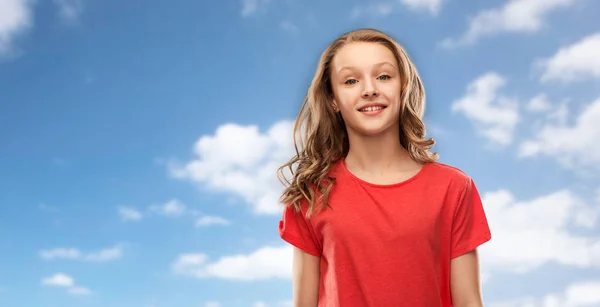 Lächelndes Teenie-Mädchen im roten T-Shirt über dem Himmel — Stockfoto