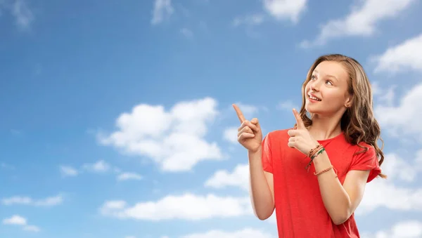 Smiling teenage girl pointing fingers to something — Stock Photo, Image