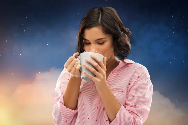 夜にマグカップからコーヒーを飲むパジャマで女性 — ストック写真