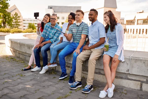 Amigos felices tomando selfie por teléfono inteligente en la ciudad — Foto de Stock