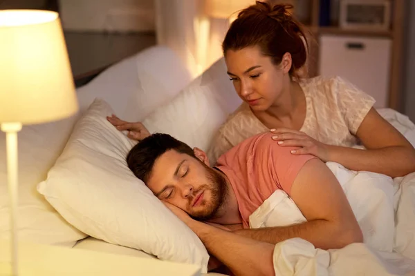 Vrouw wordt wakker haar slapende echtgenoot in bed thuis — Stockfoto