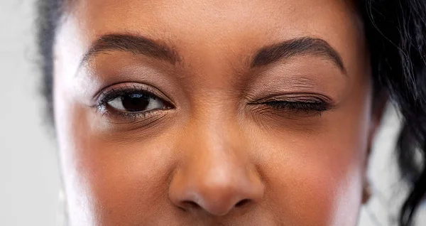 Närbild av afrikansk amerikansk kvinna blinkning ett öga — Stockfoto