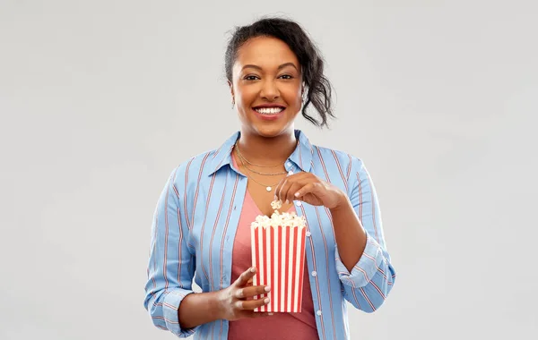 Gelukkig afrikaanse amerikaanse vrouw eten popcorn — Stockfoto