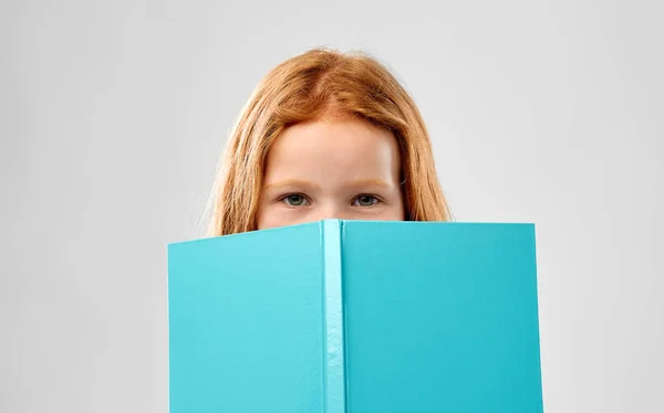 笑顔の赤い髪の少女の読書本 — ストック写真