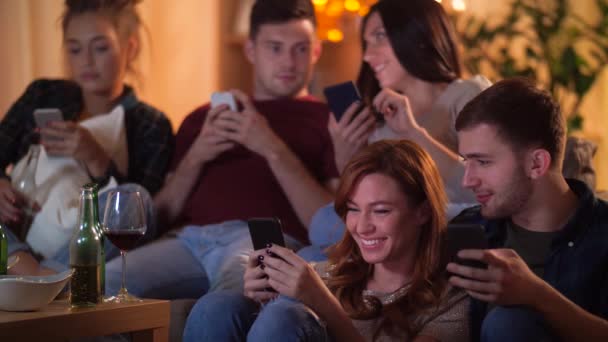 Amici con smartphone guardando la tv a casa — Video Stock