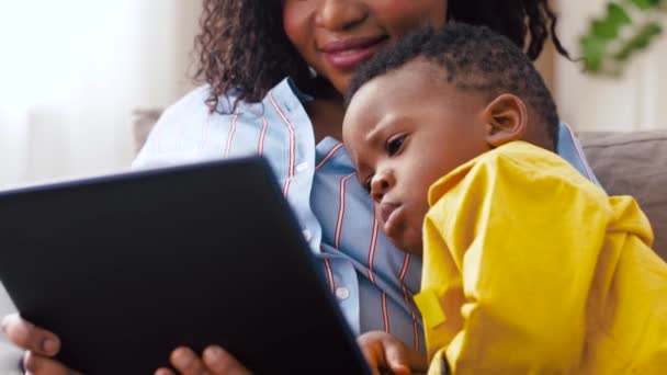 自宅で赤ちゃんの息子とタブレット pc を使用している母親 — ストック動画