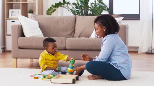 Мать и ребенок играют с игрушками блоки дома — стоковое видео