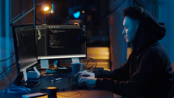 Хакер в толстовке с помощью компьютеров для кибератаки — стоковое видео
