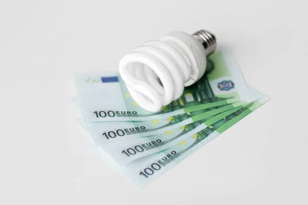 Close-up de lâmpada de poupança de energia e dinheiro do euro — Fotografia de Stock