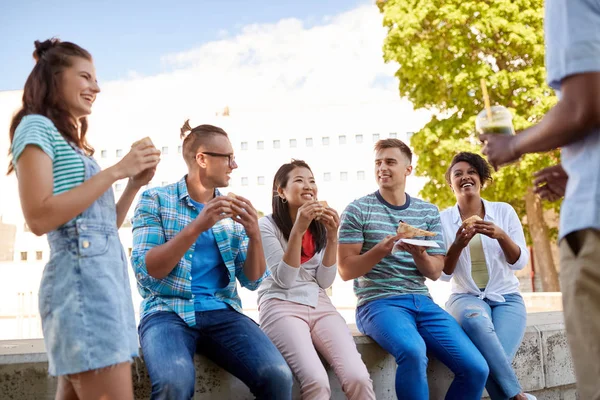 Vänner äter smörgåsar eller hamburgare i parken — Stockfoto