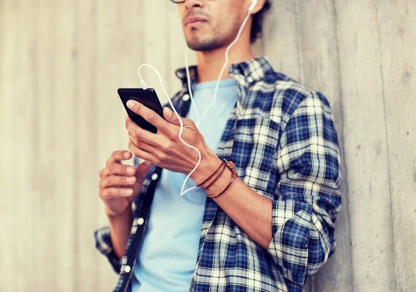 Man met oortelefoons en smartphone luisteren muziek — Stockfoto