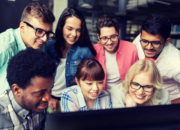 Studenti internazionali con computer in biblioteca — Foto Stock