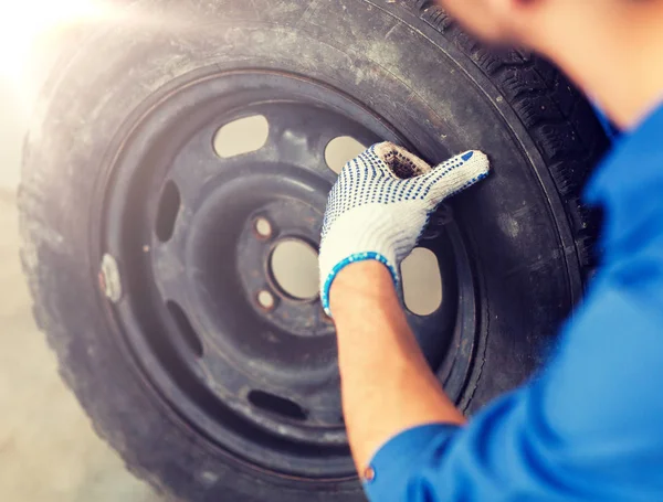 Mechanic with wheel tire at car workshop — Stock Photo, Image