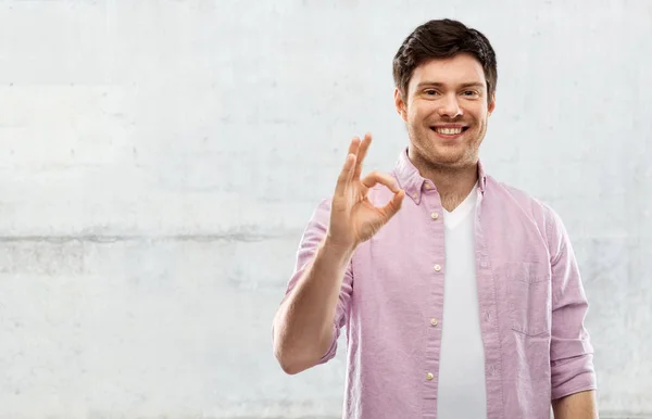 Lächelnder junger Mann zeigt Handzeichen — Stockfoto