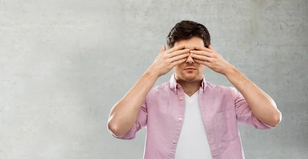 Άνθρωπος κλείνοντας τα μάτια του με τα χέρια πάνω από τσιμεντένιο τοίχο — Φωτογραφία Αρχείου