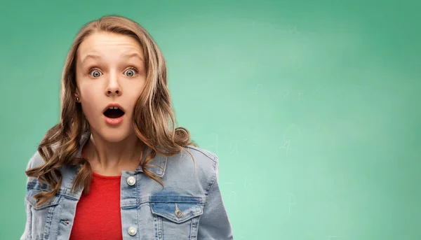 Surprised student girl over green background — Stock Photo, Image