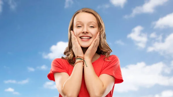 Adolescente souriante en t-shirt rouge sur le ciel — Photo