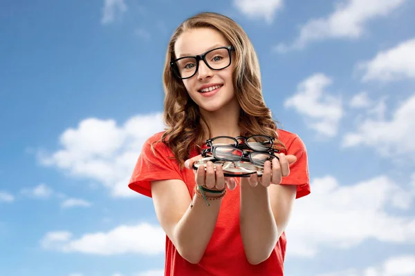 Adolescente estudante menina segurando óculos sobre o céu — Fotografia de Stock