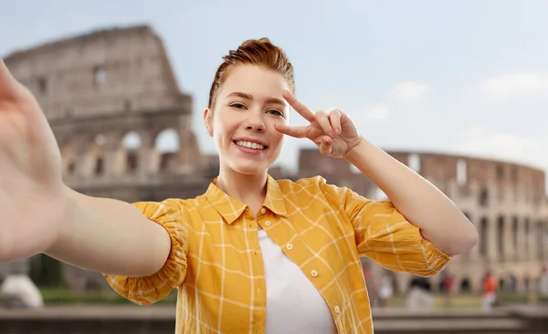 Рыжая девушка-подросток делает селфи над Колизеем — стоковое фото