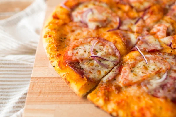 Close-up de pizza caseira na mesa de madeira — Fotografia de Stock