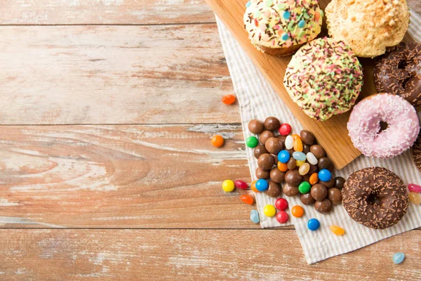 Primo piano di ciambelle glassate, caramelle e cupcake — Foto Stock