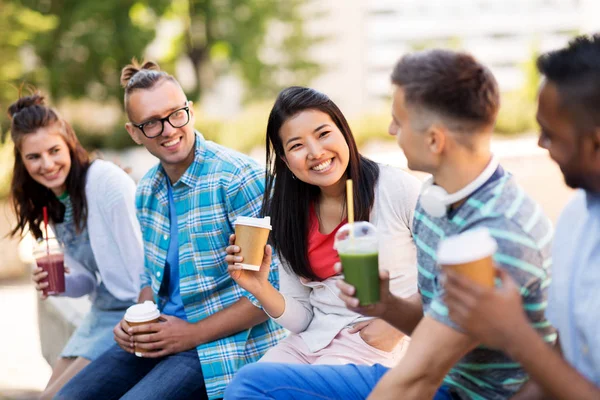 Friends drinking coffee and juice talking in city — Stock Photo, Image