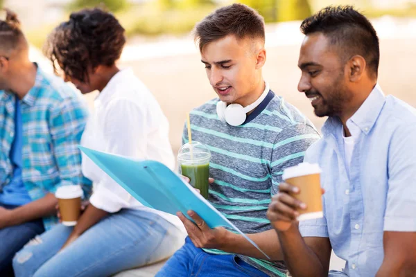 Estudantes com caderno e bebidas takeaway — Fotografia de Stock