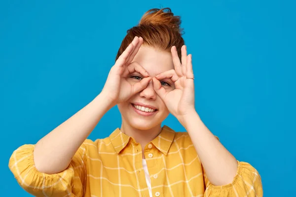 Red haired teenage girl making finger glasses — Stock Photo, Image