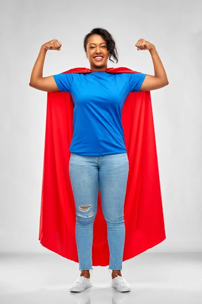 Mujer afroamericana feliz en capa roja de superhéroe —  Fotos de Stock