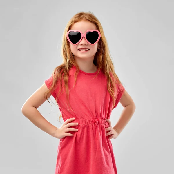 Kalp şeklinde güneş gözlüğü gülümseyen kırmızı saçlı kız — Stok fotoğraf