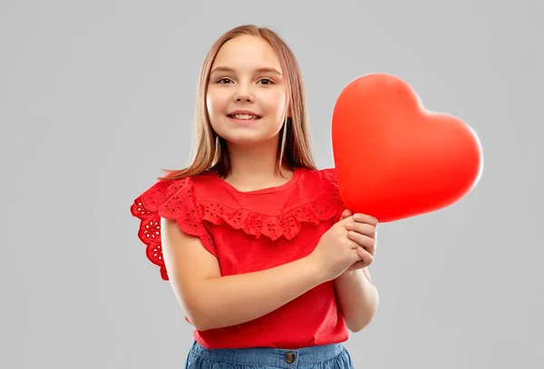 Kırmızı kalp şeklinde balon ile gülümseyen kız — Stok fotoğraf