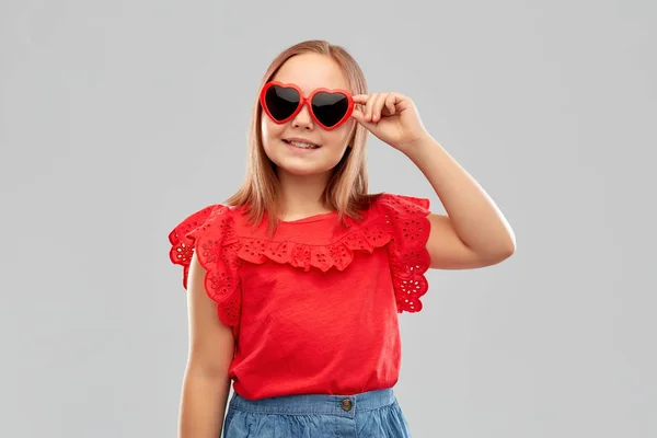 Niña preadolescente sonriente con gafas de sol en forma de corazón — Foto de Stock