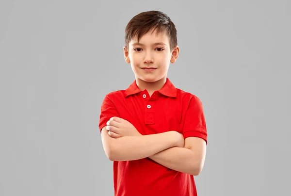 Menino sorridente em camiseta vermelha com braços cruzados — Fotografia de Stock