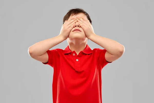 Boy in red t-shirt closing his eyes by hands — Stock Photo, Image