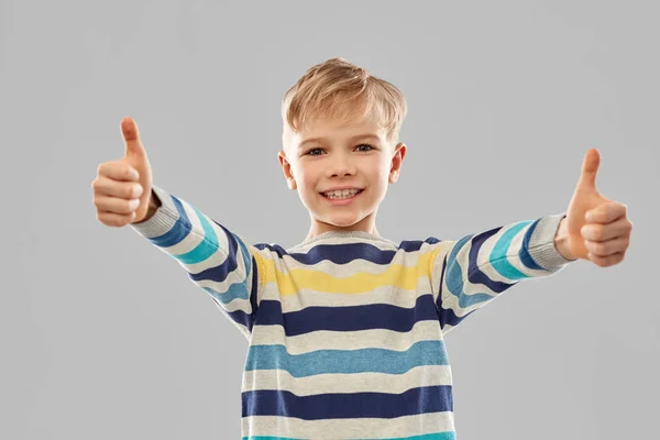 Smiling boy in striped pullover showing thumbs up — Stock Photo, Image