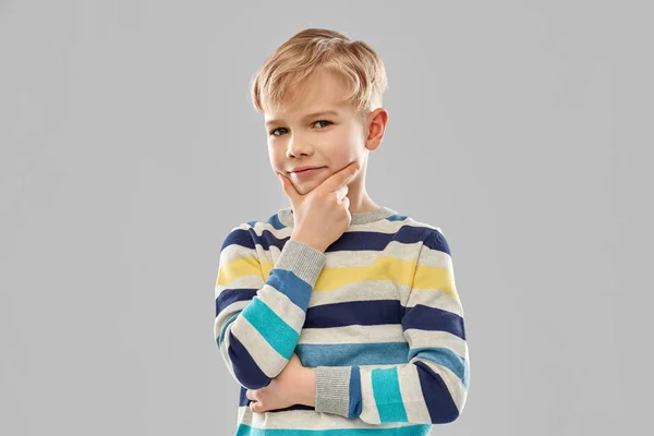 Портрет думающего мальчика в полосатом свитере — стоковое фото