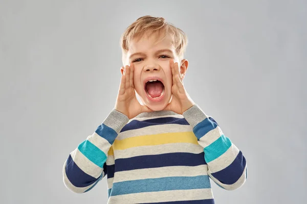 Wütender kleiner Junge in gestreiftem Pullover schreit — Stockfoto