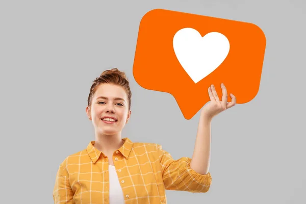 Red haired teenage girl holding heart icon — Stock Photo, Image