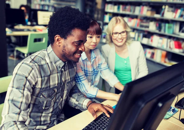 Estudantes internacionais com computadores na biblioteca — Fotografia de Stock